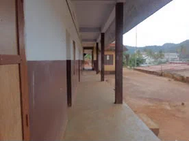 A covered veranda along the classrooms, looking out to the hills